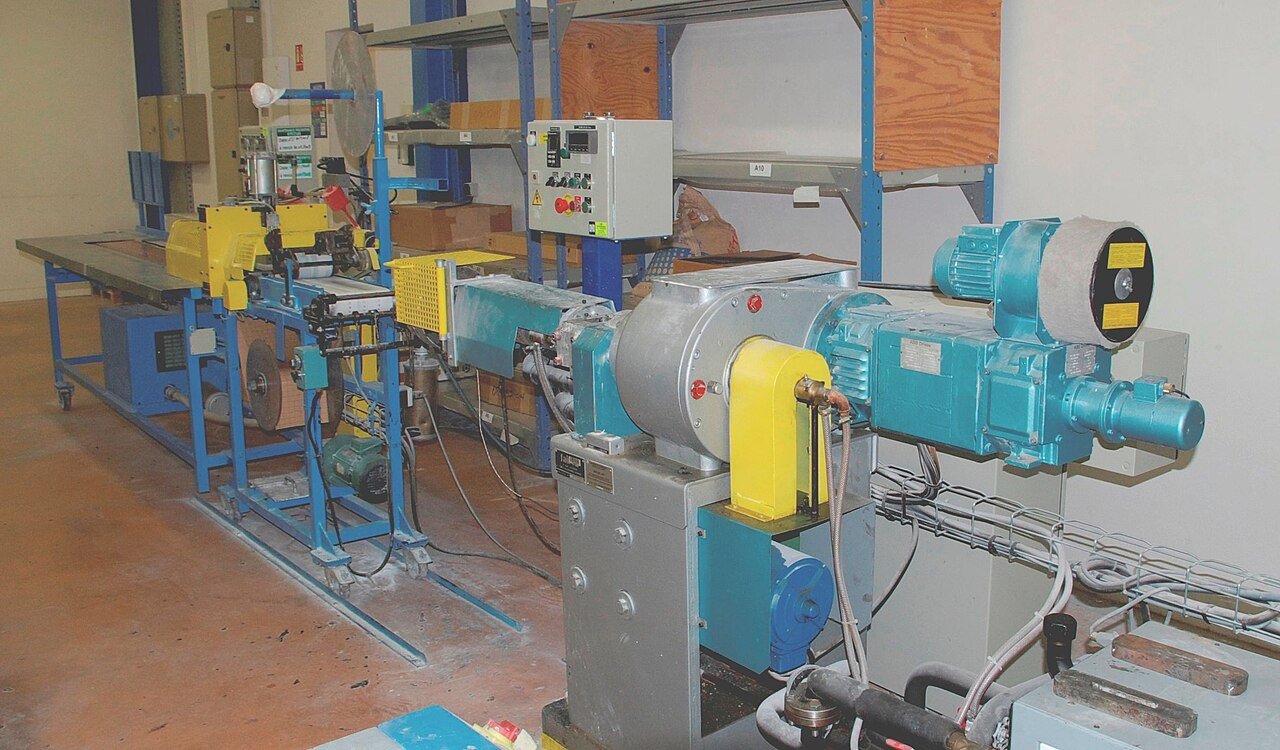 Real industrial plastic extrusion machine with dies and conveyor